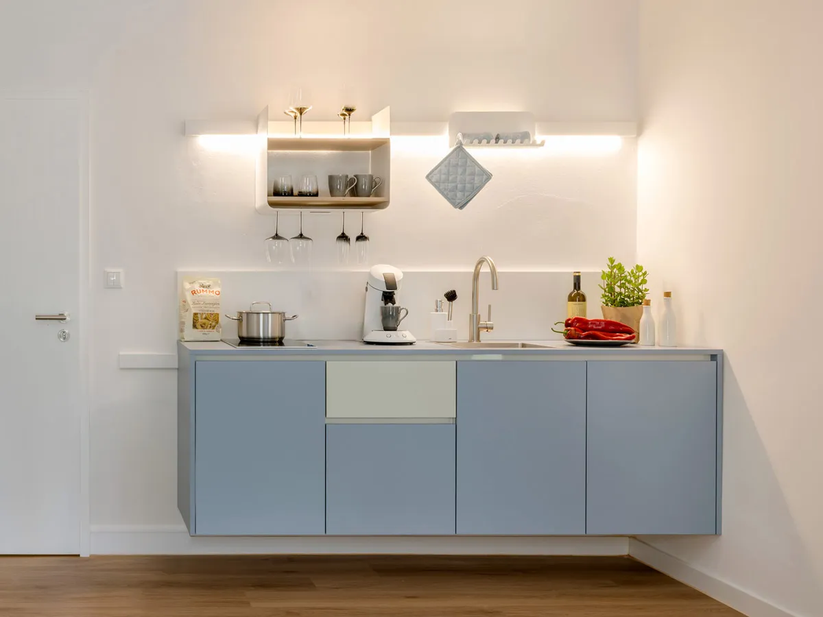 Küchenzeile mit beleuchtetem Regal, Gläserhalter und Topflappen am Haken