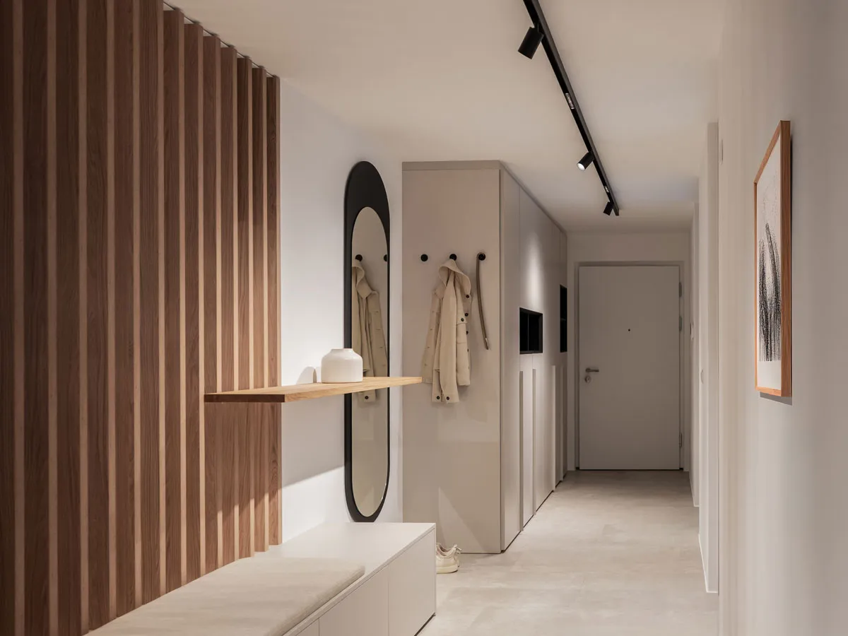 Garderobe im Flur mit Holzlamellenwand, ovalem Spiegel und Sitzbank