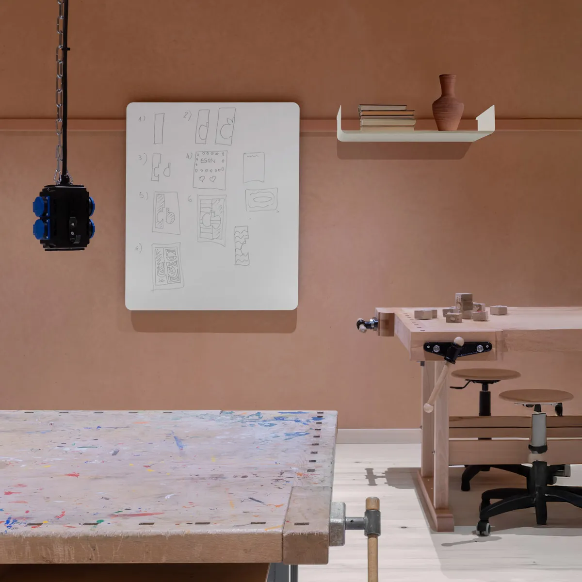 Werkraum mit Hobelbänken, Whiteboard und Ablage an der Wandleiste