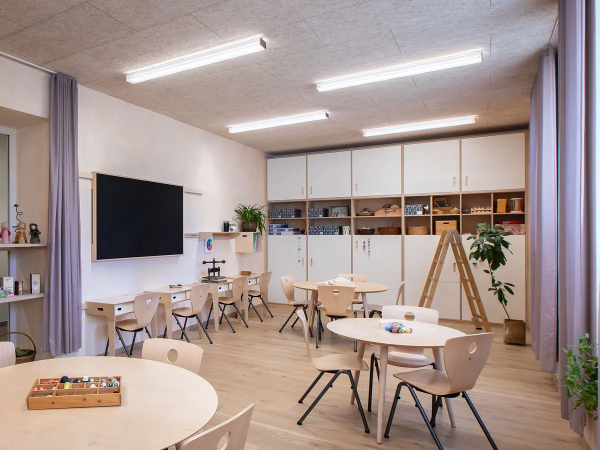 Handarbeitsraum mit Tafel, Schrankwand und runden Tischen