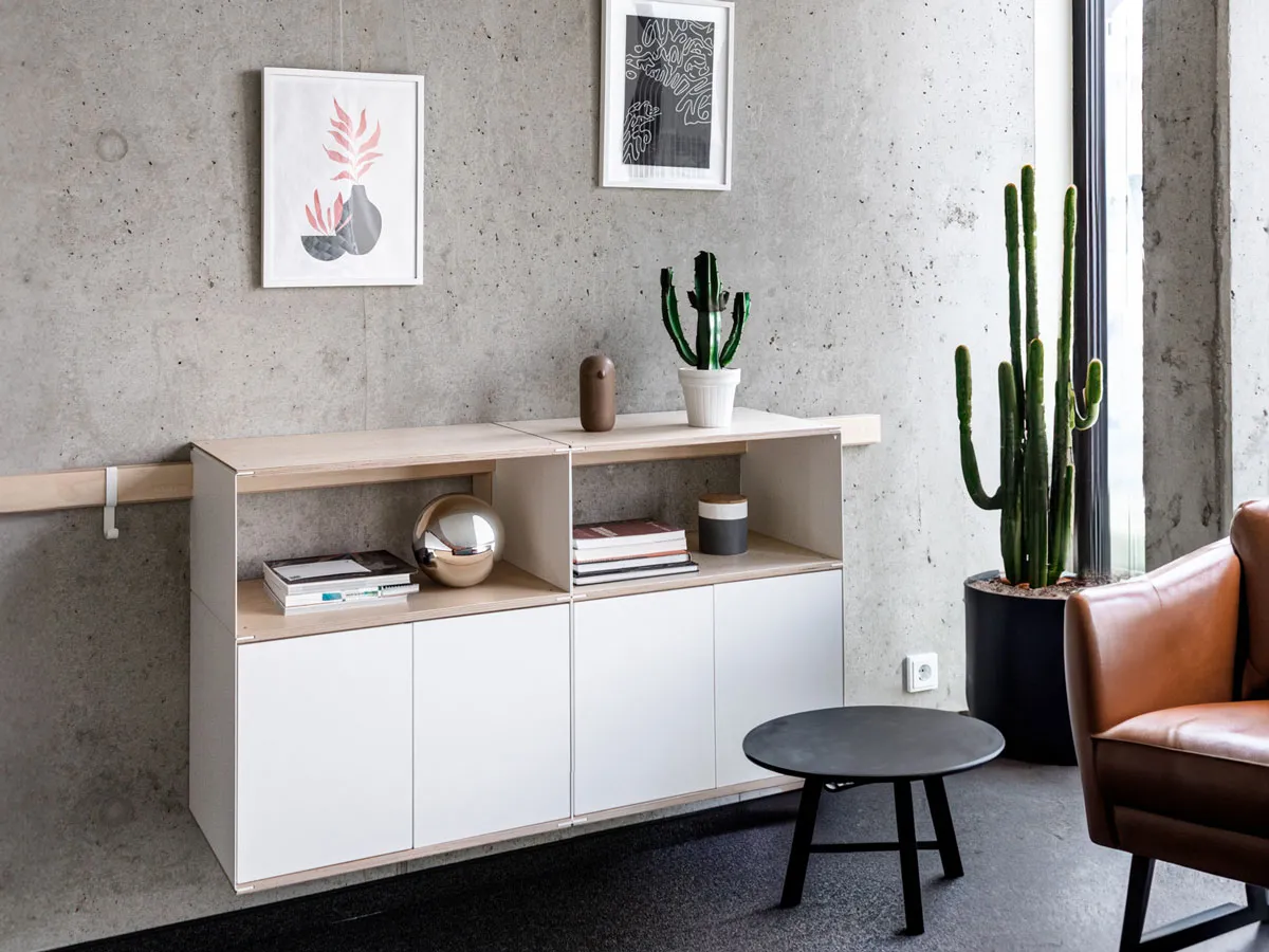 Hängendes Sideboard an der Wandleiste vor der Sichtbetonwand
