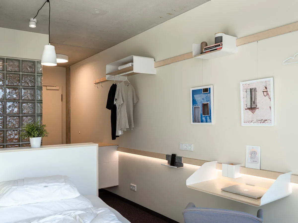 Apartment mit Garderobe, Wandregal und beleuchteter Arbeitsablage